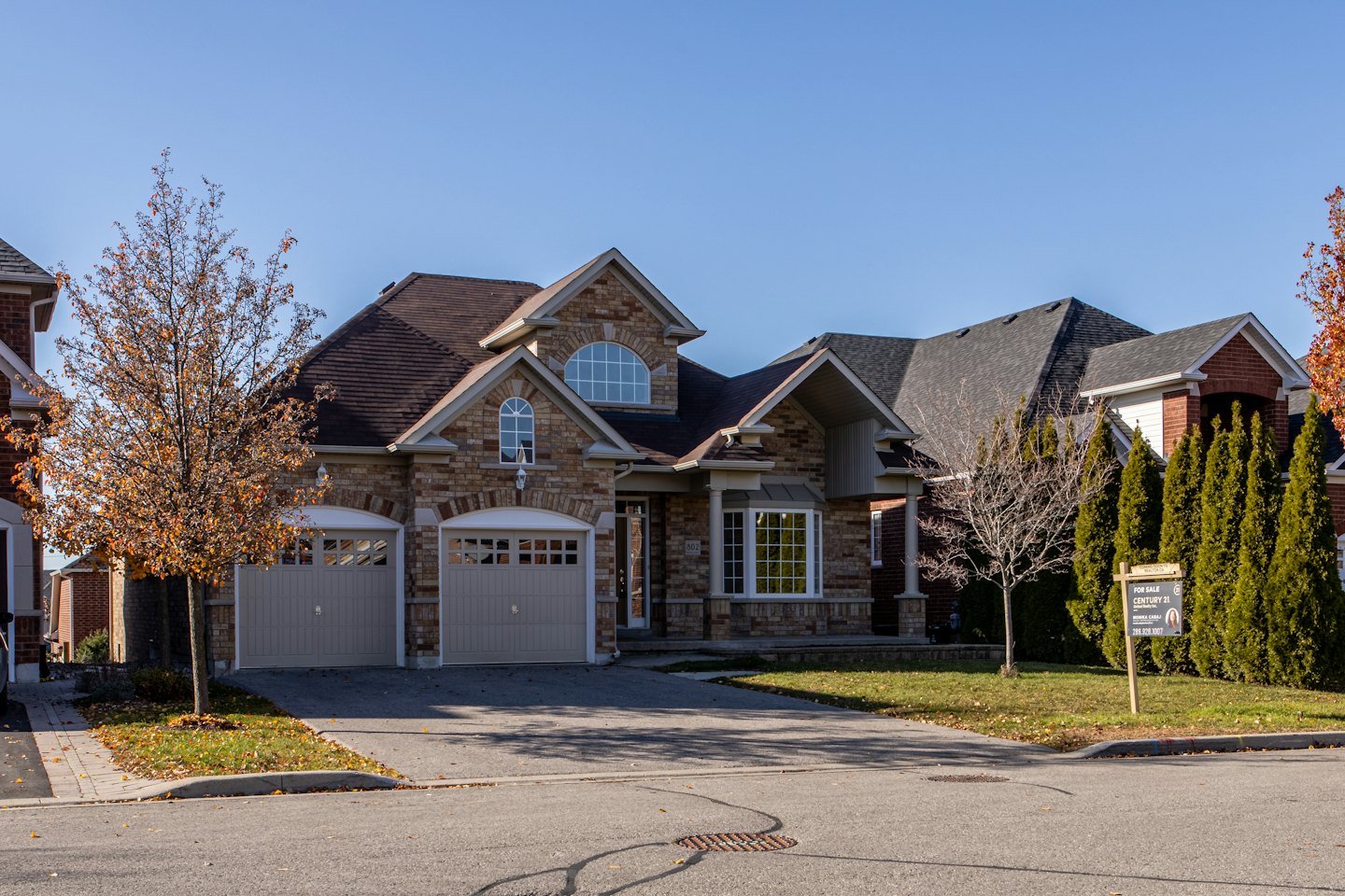 Modern house with for sale sign on lawn.